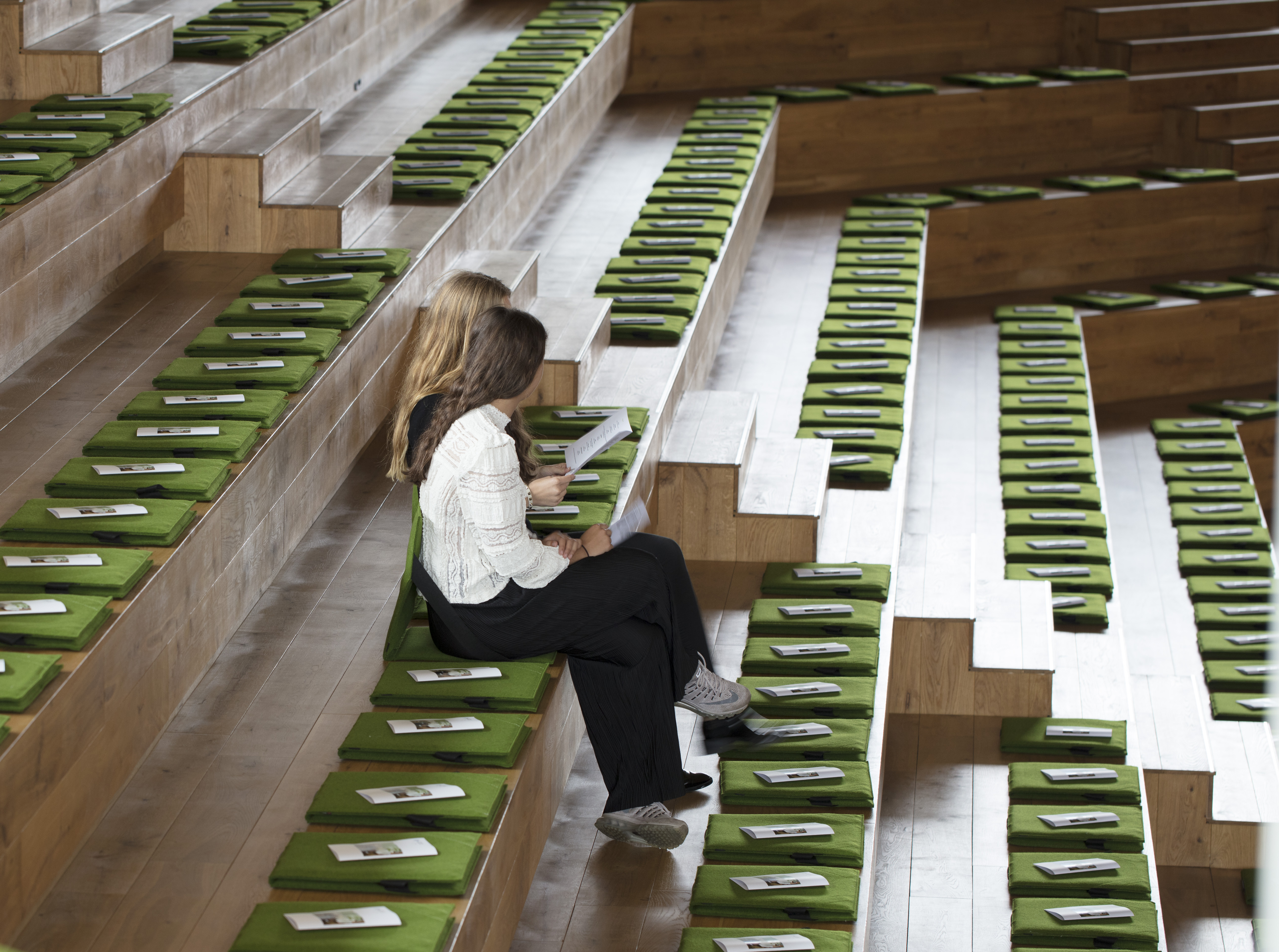 Fold ud stol i grøn filt i auditorium