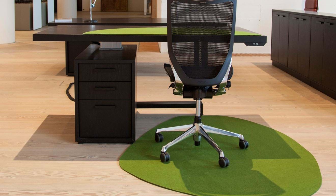 Grønt stoleunderlag i filt beskytter trægulvet på kontor