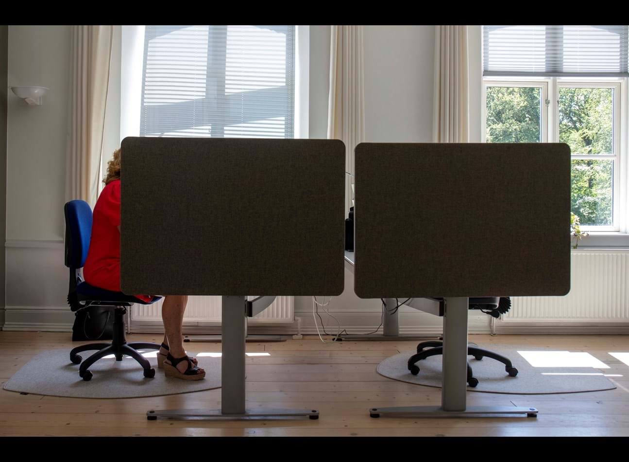 Stoleunderlag i filt og kvinde i rød kjole på kontorstol